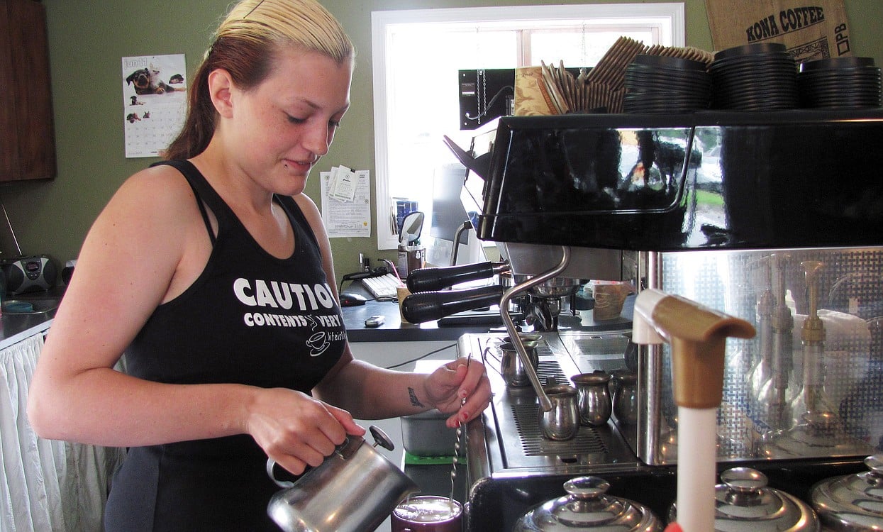 Paige McKnight, a barista at Michele's Coffee Corner, in Washougal, makes a white chocolate caramel mocha Monday. The "E" Street business, owned by McKnight's mother Michele, has experienced a decline in business due to the economy as well as recent roadwork. The "E" Street construction project, which involves conversion of the road width to two through-lanes and a center left turn lane, as well as bike lanes and sidewalks from Sixth to 32nd streets, is expected to be completed in September.