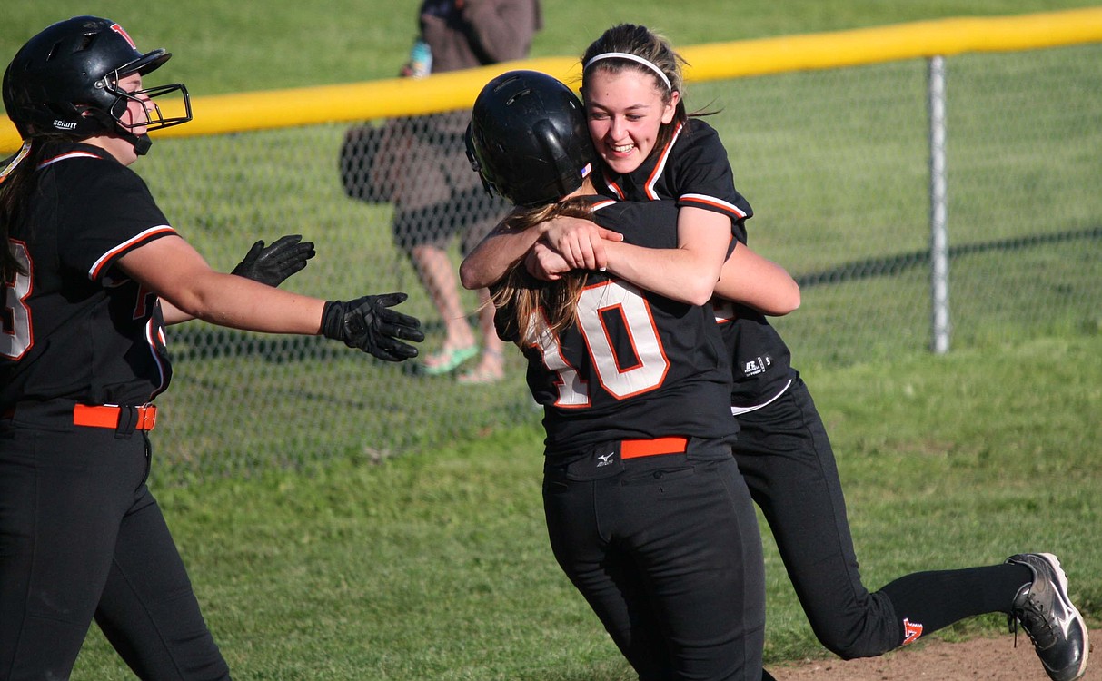 Kayla Lagerquist (left) and Abby Young (right) pounce on Madisen Baldwin after she drove in the tying and winning runs for Washougal in the bottom of the seventh inning. The Panthers beat Mark Morris 5-4 Monday, to get to the district tournament for the first time since 2004.