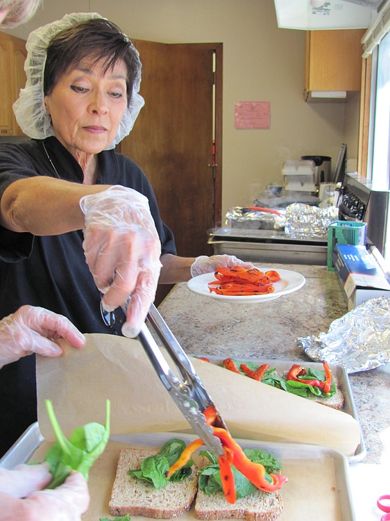 Alla Fleischer prepared sandwiches with lemon chicken and roasted red peppers, with assistance from volunteer Lynne Foster, Friday at the Camas Community Center. Fleischer, kitchen coordinator for The Meals on Wheels People Camas-Washougal, will retire at the end of this week. Cake and ice cream will be served in her honor Thursday, at the Washougal Community Center.