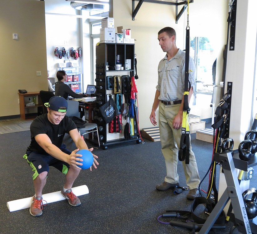 Guy LaRue builds strength and flexibility with physical therapist Steve McCarthy at Washougal Sport & Spine. LaRue broke his back in a quad riding accident in 2010. McCarthy is helping him make a full recovery.