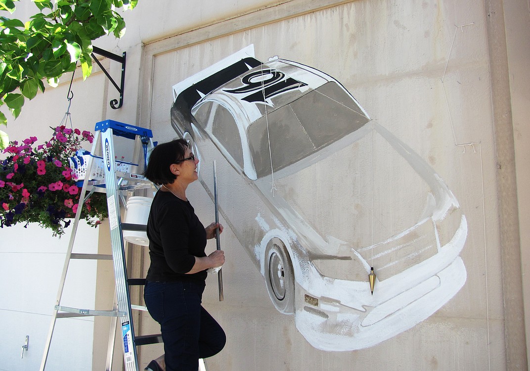 Maria Grazia Repetto measures every nook and cranny while she paints a Ford Fusion racing car made famous by NASCAR driver and Camas native Greg Biffle. This is her second painting for the Camas-Washougal "Yesterday, Today and Tomorrow" Mural Project.