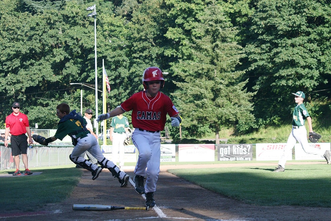 Dante Humble comes home on a sacrifice fly by Caden Wengler to score the first run for the Camas 11- to 12-year-old all-star team in the district championship game Monday, at Forest Home Park. Camas defeated Evergreen 2-0.