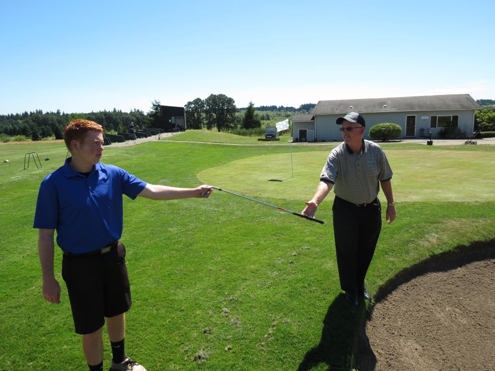 Connor Coombs hands a sand wedge to his father. Green Mountain golf course general manager Kevin Coombs is going to play in the U.S. Senior Open Thursday, July 11, at Ohama (Neb.) Country Club. His son, Connor, will be his caddy.