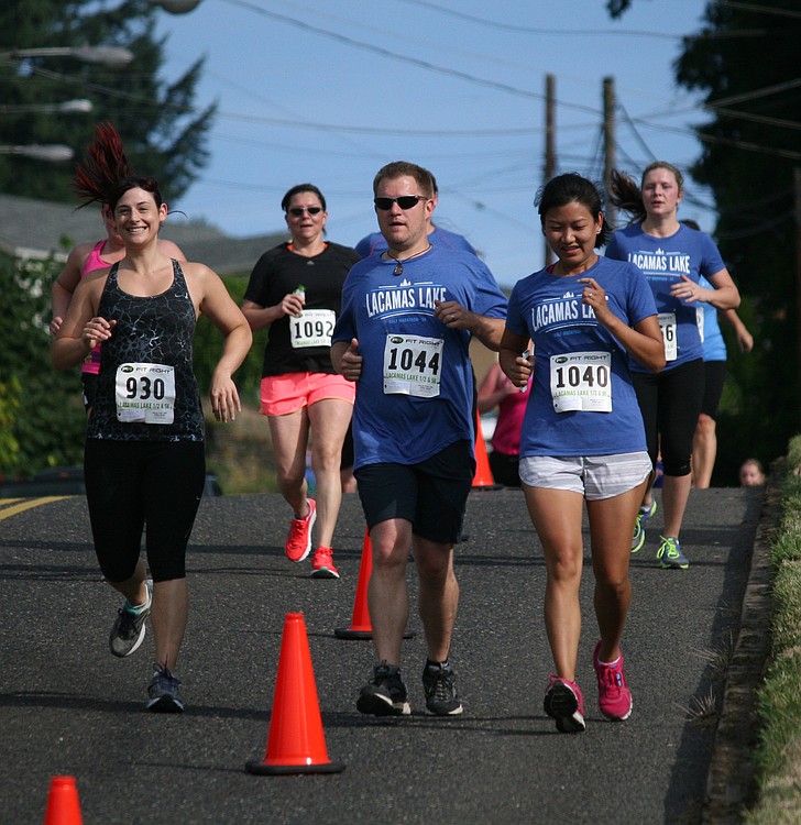 A pack of Lacamas Lake Half Marathon and 5K runners head down the hill on Dallas Street toward the finish line on Fourth Avenue Sunday.