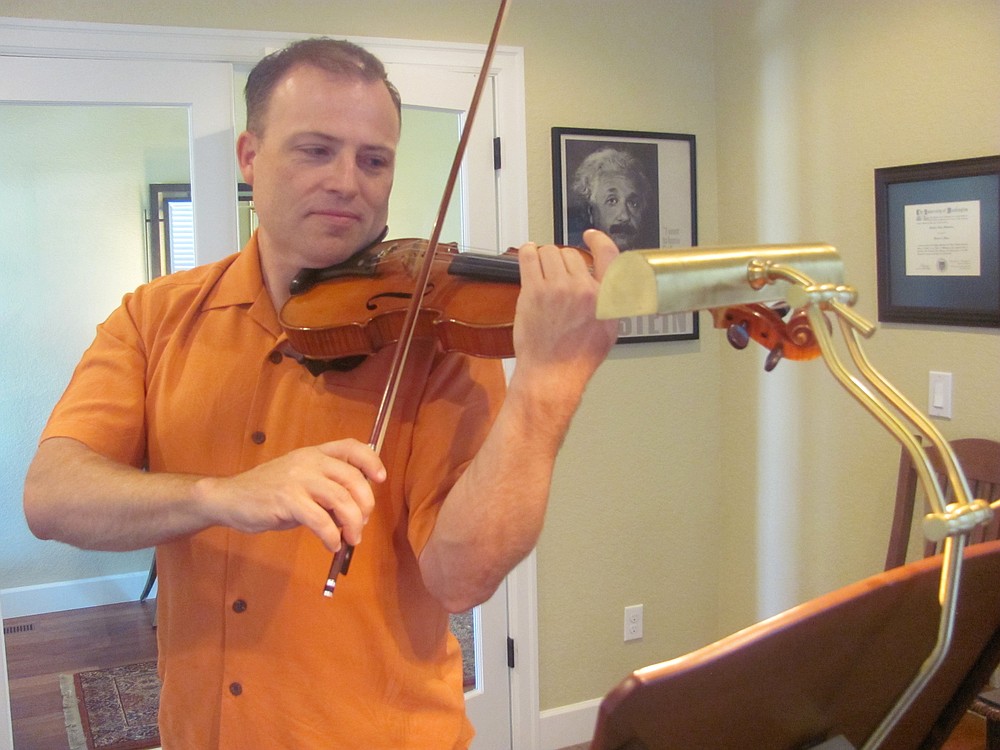 Matt Mandrones practices playing his violin at home in Camas. He said there is a poster of Einstein in his studio, because the physicist was a deep thinker and he played the violin. Mandrones is a member of several orchestras in the region. He is a string orchestra teacher with the Evergreen School District and is also available to teach private violin lessons. In addition to playing at concerts, weddings and church services, Mandrones performs as a strolling violinist at restaurants and retirement/assisted living facilities.