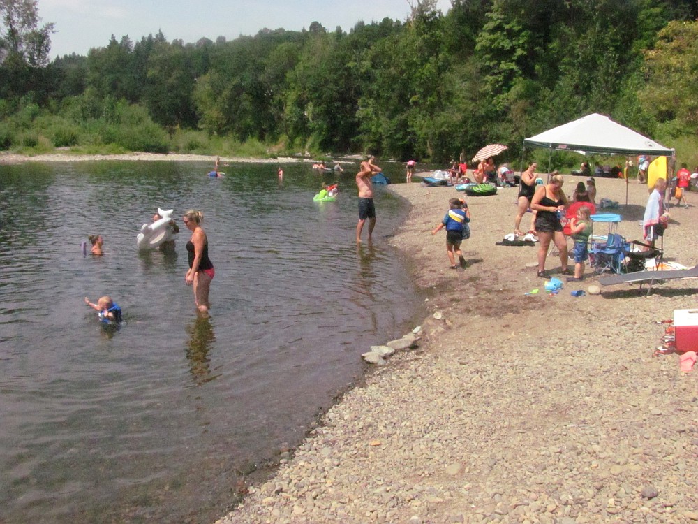 Area residents spent time at the Sandy Swimming Hole Monday, enjoying picnics, sunbathing, rafting and cooling off in the Washougal River, as temperatures neared 100 degrees. Last night, the Washougal City Council voted 4 to 2, against purchasing land from Riverside Seventh-day Adventist Church to create a park and overflow parking for users of the Sandy Swimming Hole.