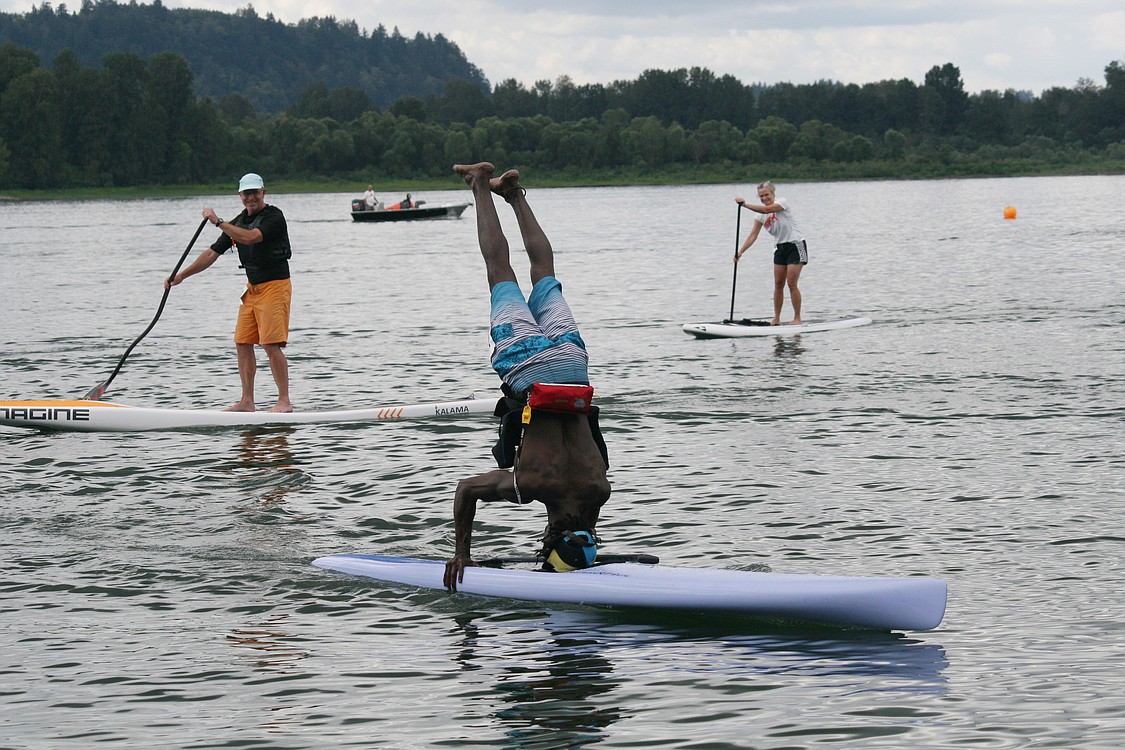 Lucien Seymour does a headstand on his paddleboard while crossing the finish line. The 29-year-old traveled to Washougal from the Bahamas to paddle on the Columbia River.