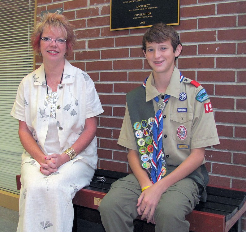 Michael Knight sits with Liberty Middle School Principal Marilyn Boerke on one of the five benches he made for the school as a part of his Eagle Scout project last year.