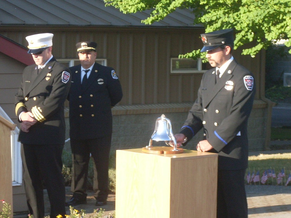 Cliff Free, division chief of emergency medical services with the Camas-Washougal Fire Department, pauses as Firefighter/Paramedic Ben Silva rings a bell and retired Fire Capt. Larry Saari looks on in front of C-W Fire Station 171, in Washougal, Wednesday morning. The tribute to the thousands of people who died as the result of terrorists' acts Sept. 11, 2001 included comments from Free, Saari, Fire Chief Nick Swinhart and Washougal Mayor Sean Guard. "Twelve years ago, a horrible act happened to our great nation," Saari said. "Today we will have time to think about all those who were lost, far too early in life and of the heroes who did what they had to do to save so many lives." Trumpet player Isaac Hodapp, a sophomore at Camas High School, performed "Taps." After the ceremony, a complimentary breakfast was provided by members of the East Clark Professional Firefighters. Saari and staff members placed more than 300 small American flags along the entryway to the fire station Tuesday. The streets of downtown Camas and Washougal were also lined with flags installed by members of the Veterans of Foreign Wars Schick-Ogle Post 4278.