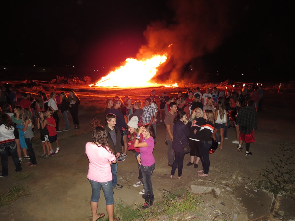 Washougal High School students gather around the fire to celebrate the return of the fall sports season Wednesday, at the former Hambleton Brothers Lumber Mill Property.
