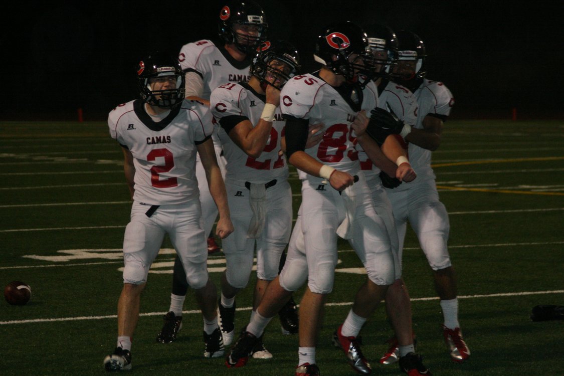 The Camas defenders celebrate with Connor Maloney (85) after he knocked the wind out of a Union receiver Friday, at McKenzie Stadium. The Papermakers shut out the Titans 22-0.