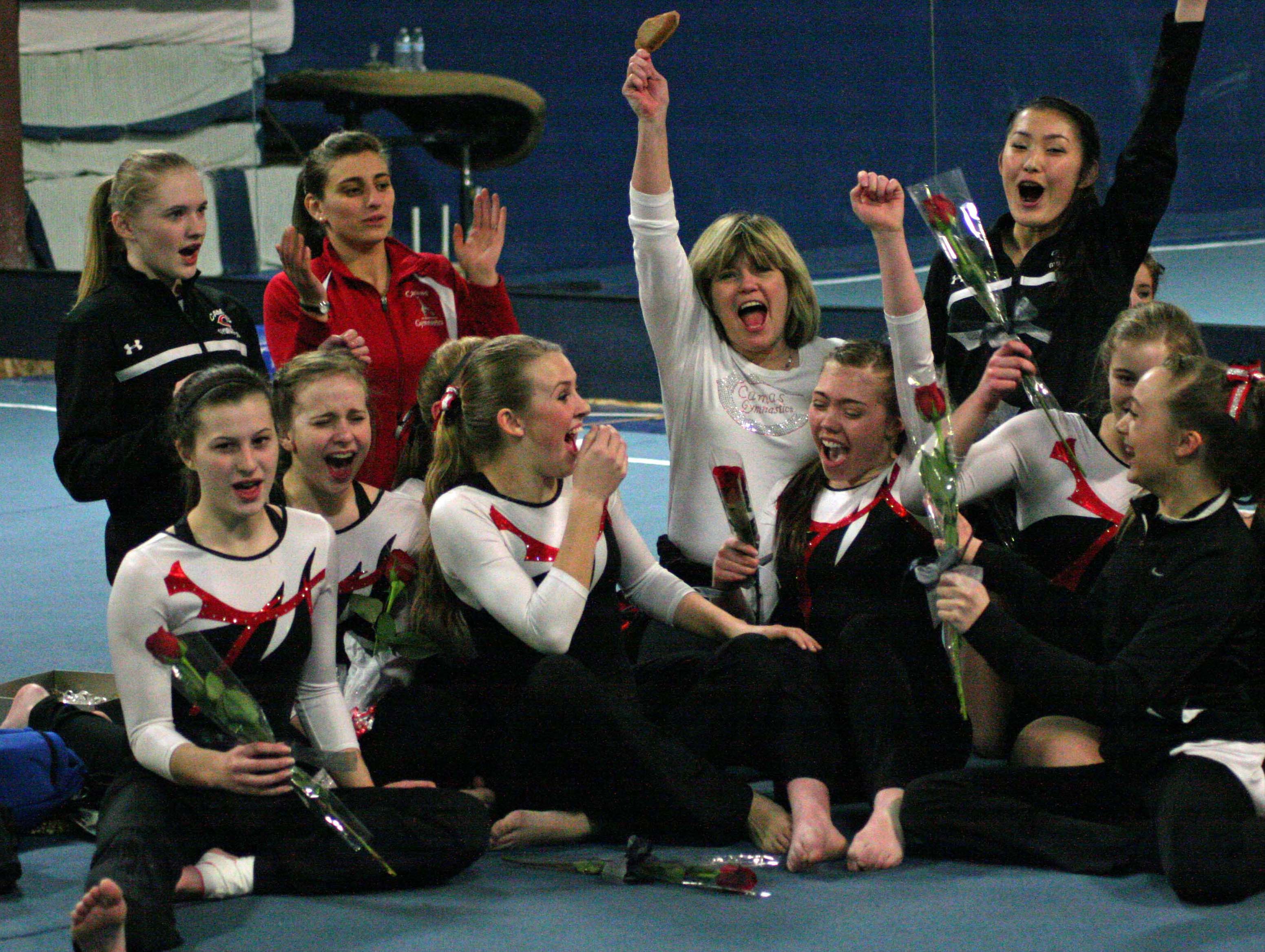 The Camas High School gymnasts celebrate with their coaches after being announced as the district champions, at Northpointe in Vancouver.