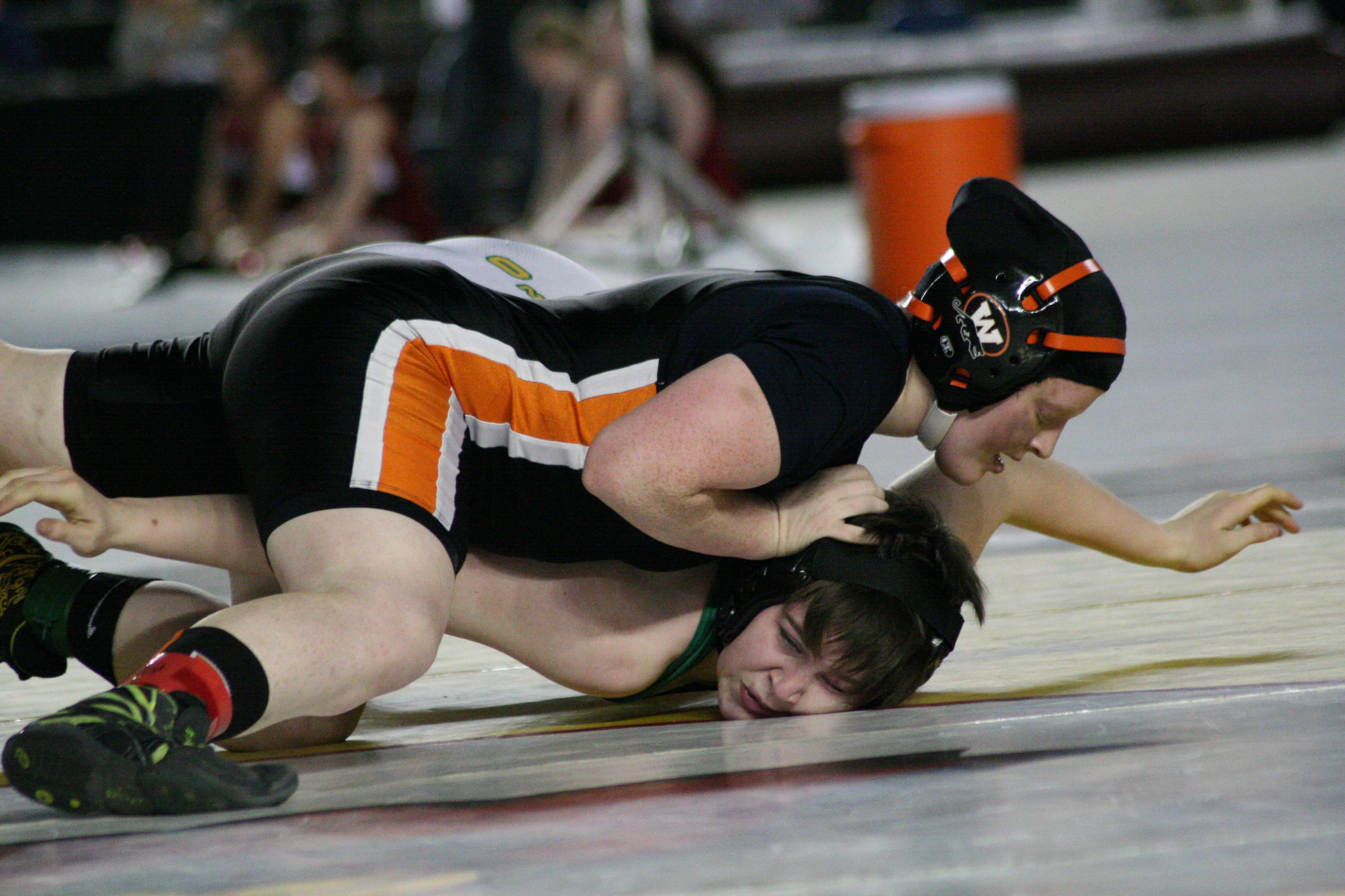 Washougal freshman Abby Lees drills Tumwater's Megan Johnson's face in the mat during the first round of the girls 155-pound state championship match, at the Tacoma Dome.