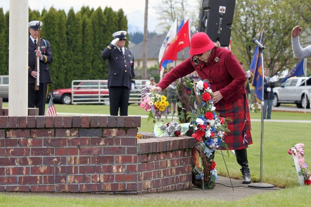 Ninety-four-year-old Lila Trammell, representing the Gold Star Mothers and wearing the Robertson family tartan, places a bouquet of flowers during the Memorial Day ceremony at the Washougal Memorial Cemetery. Trammell's mother, Inez Butler, was a member of the Gold Star Mothers, which is an organization of mothers who have lost a son or daughter serving in the military. Escorting Trammell on Monday were her brother, Harold Robertson, 90, and her son, Lyle Sanders, 73. Sanders said many members of his family have served in the military. "That has been a tradition of our family," he said.  "It's our country; we defend it." The event also included speeches by Dave Shoemaker and John Clapp. Shoemaker's comments, which honor two Washougal men killed during the Vietnam War, can be found at www.camaspostrecord.com.
