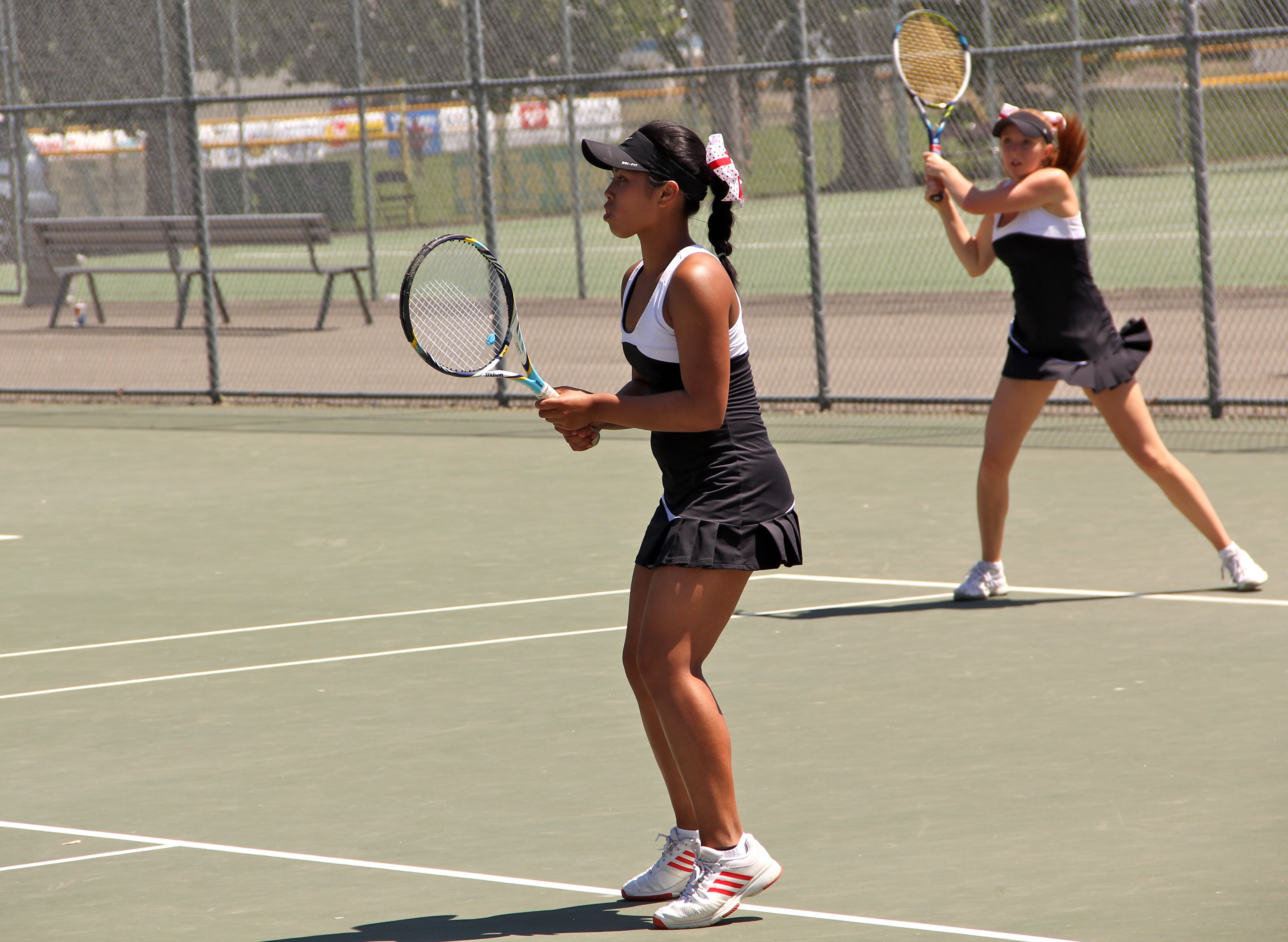 Hannah Gianan and Jen Lewis serve for a point during the state tennis tournament, in Richland.