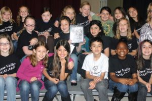 Choir members show off their first-place trophy from a recent festival. The group beat out several middle school choirs for the win.
