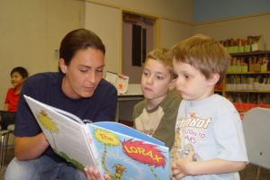 Washougal Firefighter Carly Sauters shares a book with Spencer Nicholson and Riley Gardner during the "Feed Your Brain," summer program at Hathaway Elementary School. The program includes  lunch and an afternoon literacy session for several children living in the boundaries of the Washougal School District.