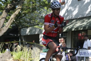 Devin Mounts of Gresham, Ore., is all smiles as he makes his way across the finish line.  Mounts, 20, placed first in a field of nine finishers in the Camas Twilight Criterium's Category 4/5 race.  A total of about 50 participants were entered into the five races held  Saturday evening in downtown Camas.