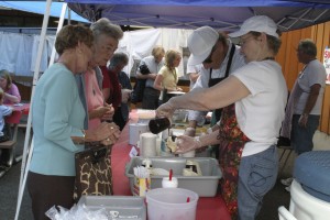 Volunteers scoop up yummy ice cream sundaes during the 2009 Heritage Day festival, held annually at the Two Rivers Heritage Museum in Washougal.  This year, several events, including Heritage Day, will take place inside and  adjacent to the museum.  The grand opening of the Washougal Pedestrian Tunnel and a classic car show are also part of the scheduled lineup.