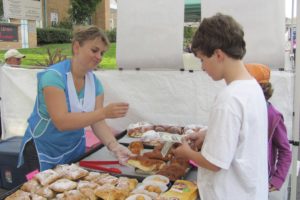 Olga Mikhalets, owner of Svitoch European Bakery, helps young customers Wednesday at the Camas Farmer's Market select a pastry.   The sweet offerings are very popular at the market, which runs through this Wednesday.