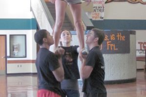 Joseph Harris (left) and James Maguire (right) form a solid base for Kayla Ferguson. As part of her senior project, Ferguson will offer a Washougal High School cheer camp for preschool to eighth grade students Oct. 18 through 22.