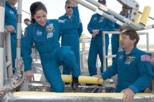 On Launch Pad 39A at NASA's Kennedy Space Center, Space Shuttle Discovery crew members receive instruction on the operation of the pad's slidewire basket system emergency exit training as part of the Terminal Countdown Demonstration Test. Inside the basket are Mission Specialists Nicole Stott (left) and Michael Barratt (right).