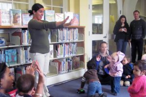 Paola London (standing, center) encourages children and their parents to sing a song in Spanish, Wednesday, at the Camas Public Library. The weekly Spanish story times, co-led by Denice Twyman (sitting, left), are designed for infants to children 5 years old and their parents.