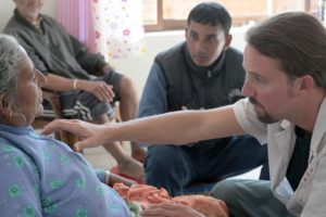 Lieth Nippes, co-founder of the Acupuncture Relief Project, works with an interpreter to examine a patient complaining of breathing problems.