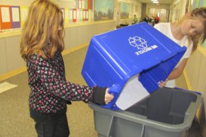 Hathaway students Shae Alder, left, and Mackenzie Desmet empty classroom recycling bins last week as part of the school's Green Team efforts.