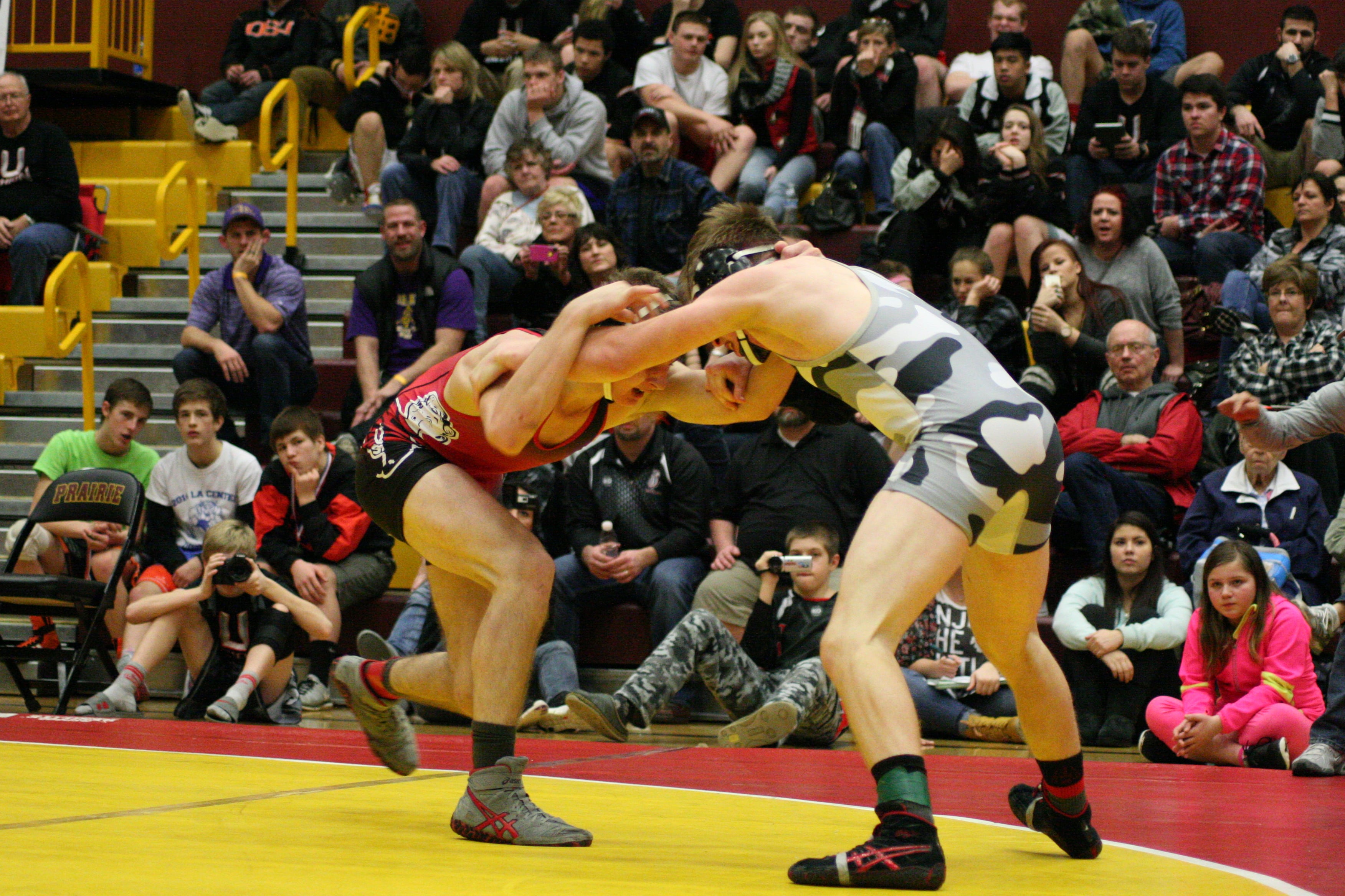 The crowd hits fever pitch as both wrestlers leave it all out on the mat in the final round. Tommy Strassenberg held on for a 5-3 victory against Bryant Elliott in the 145-pound boys county title match.
