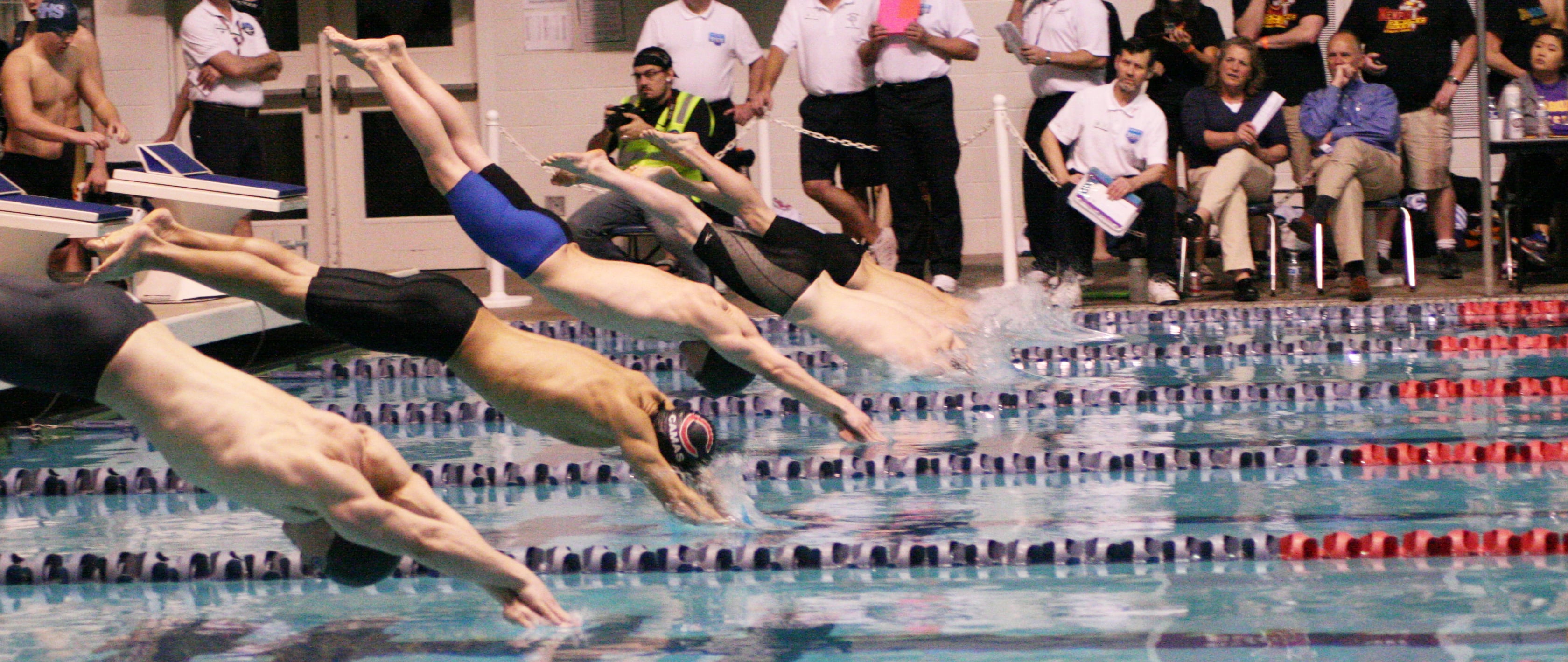 John Utas dives in with the other swimmers to begin the 200 freestyle relay preliminary race.