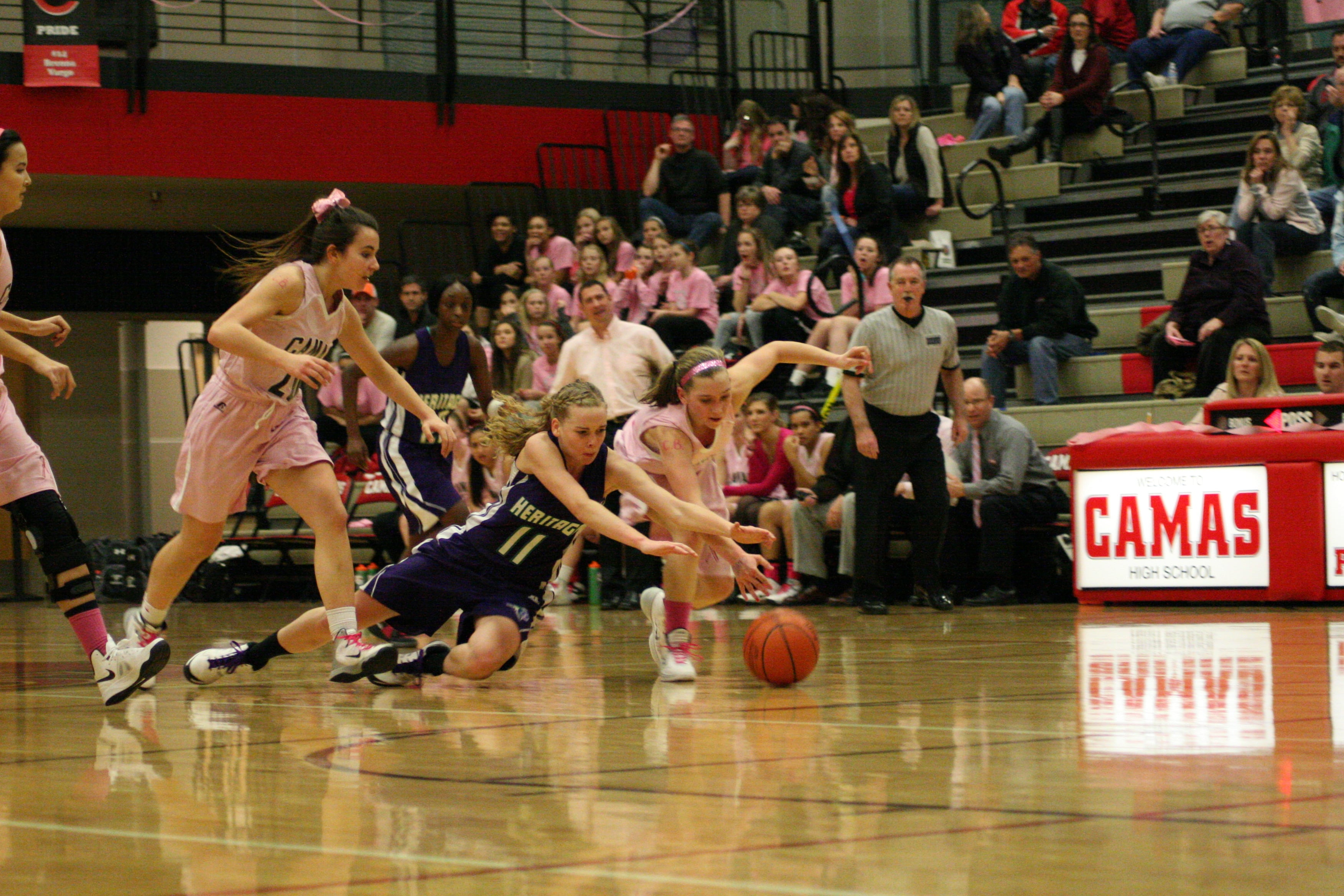 Camas freshman Meghan Finley and a Heritage girl fight for possession of the basketball.