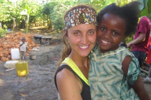 Molly Adamson holds a little girl at a small village called Rakai, where she and other volunteers built a two-room house for an widow who had previously been living in a thatched roof hut. For more information about the organization, visit www.empower-a-child.org.