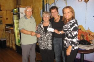 Nancy Viuhkola (far right), community affairs coordinator with Georgia-Pacific and Carrie Schulstad (second from right) of the Downtown Camas Association presented a check for $1,075 to Bob Howe (far left), treasurer of Camas-Washougal Community Chest, and Nancy Wilson (second from left), executive director of the Inter-Faith Treasure House food bank. The funds were raised during the Camas Car Show on July 2.