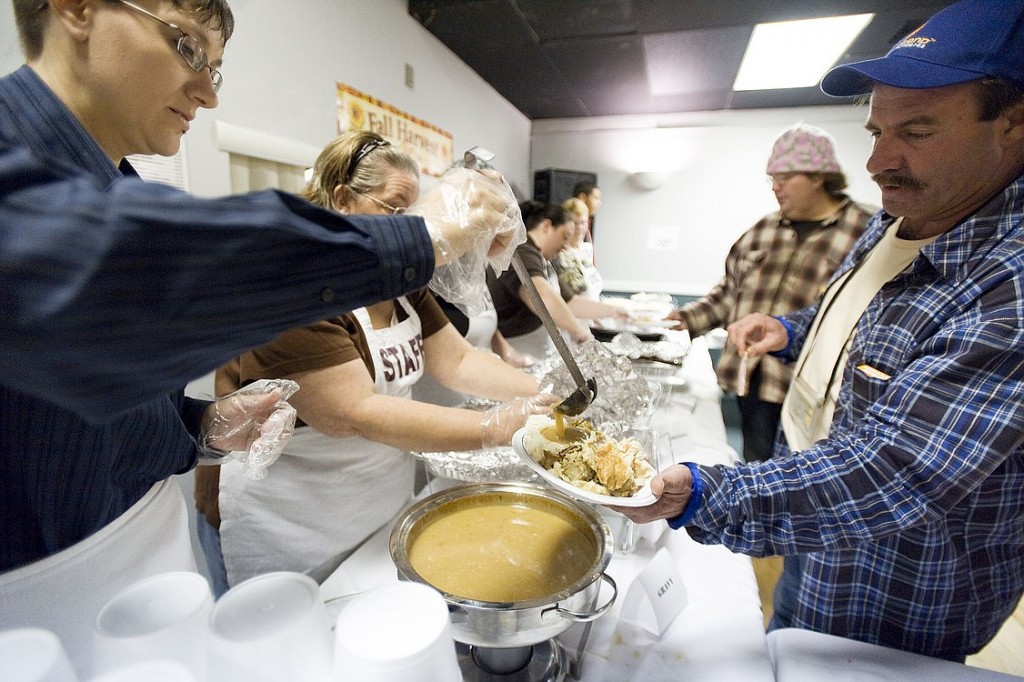 Volunteer Michelle Minkler pours gravy on Ray Brenner's Thanksgiving dinner Thursday at the Eagles Lodge in Vancouver. About 150 people helped put on the Eagles meal and more than 400 guests were served.