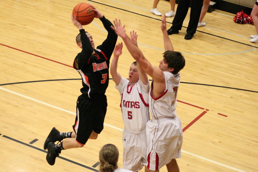 Michael McElory hovers above two Camas Papermakers and puts the ball in the basket for the Washougal Panthers Thursday.