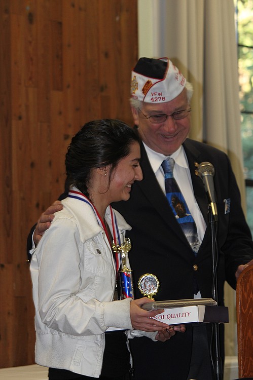 Camas High School student Amanda Felipe accepts congratulations from Steve Stetson, VFW Camas-Washougal Post 4278 member and Past State Commander, during Sunday's essay contest awards ceremony. Felipe won first place for her Voice of Democracy essay, which was written in response to the theme: "Why I'm Optimistic About Our Nation's Future."
