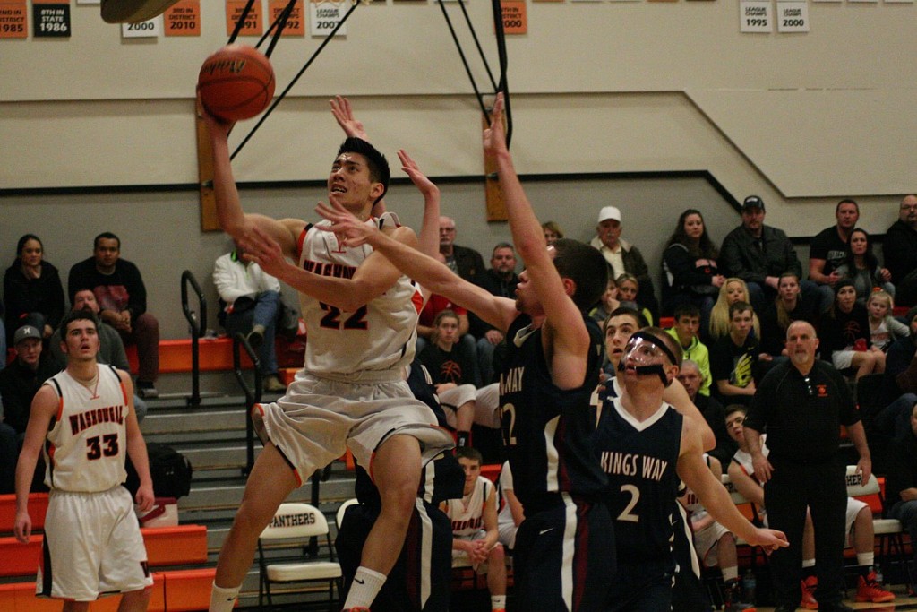 Austin Tran threads the needle around the Knights and weaves a basket for the Panthers Monday, at Washougal High School. The Panther boys and girls teams swept King's Way Christian in a double header.