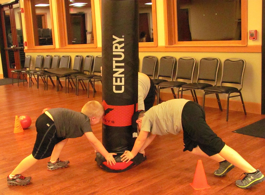 Clockwise, from left, Nathan, Brian and Tessa Hoff work their legs by doing "mountain climbers" during boot camp.
