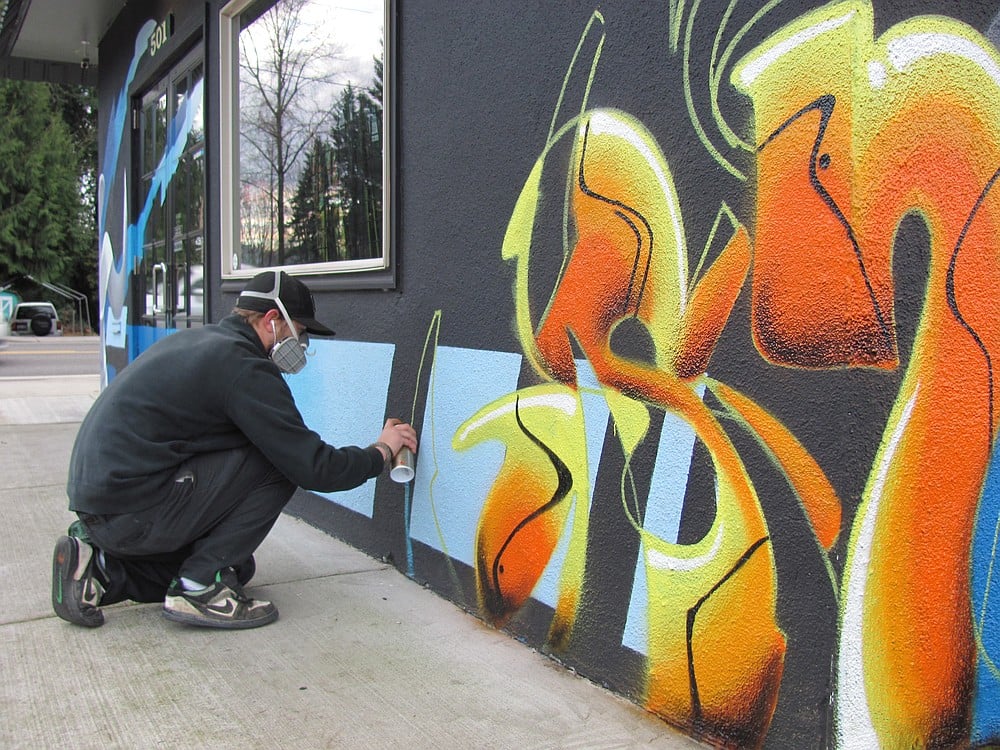 Local artist Bobby Johnson works on a "piece" at Limitless Snow-Wake-Surf in Washougal. The owner, Eric Hargrave, his him change the design every six months or so. "I let him do what he does best on the building," Hargrave said.