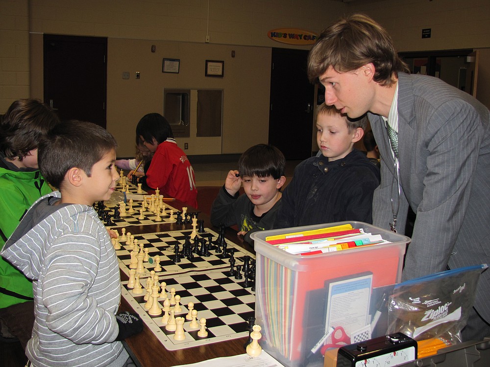 A young student talks strategy with Andrew Svehaug, former state and national chess champion, and founder of the American Chess Institute.