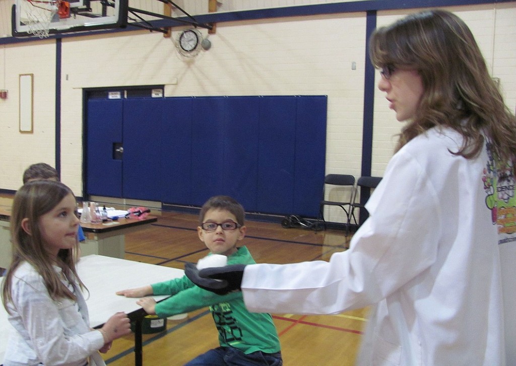 Julie Meleski "Professor Richter," lets first-grader Aubrey Schultz take a closer look at the dry ice.