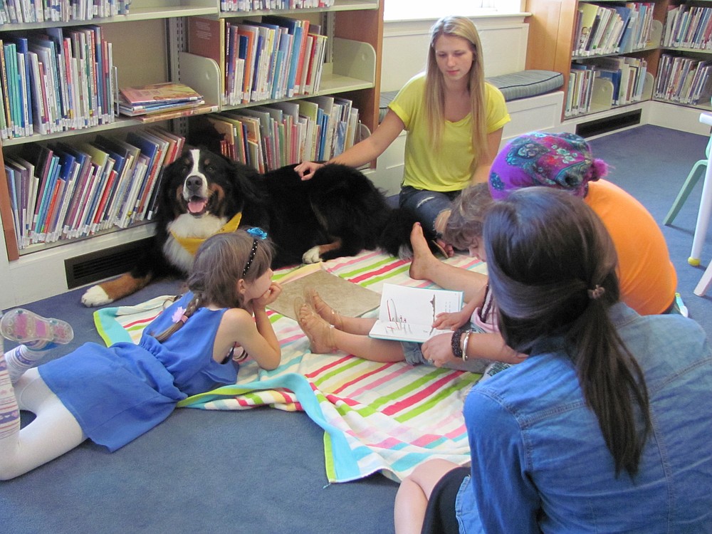"Read to the Dog," is a popular new program at the Camas Public Library, and it is also a senior project. Karen Nicholson, library associate, helps to organize it.