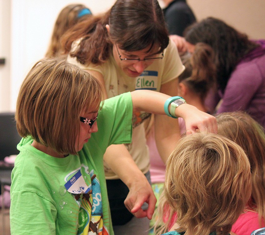 Children and their parents try to untie a human knot as part of a game during a sleepover at the Camas Public Library last fall. The event is one of the many programs the library offers free of charge.