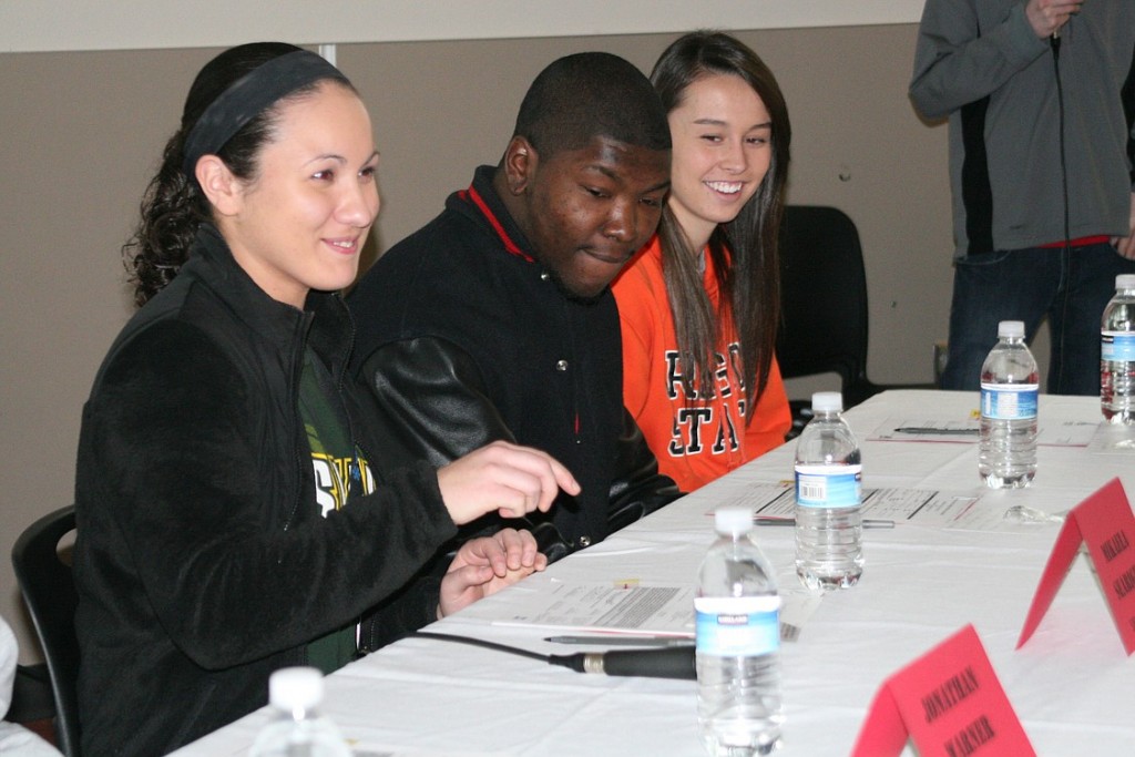 Mikaela Searight (far left) grins at the fresh ink on her signature to play softball for Siena College. This is one of many expressions of excitment shared by athletes all over the country Wednesday.