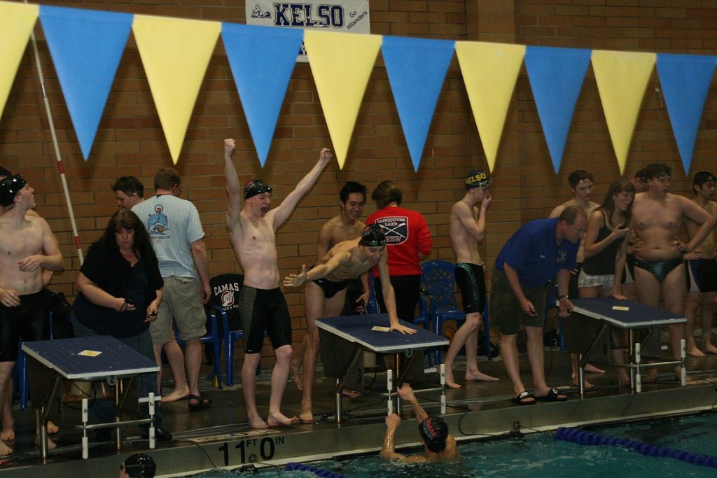 Camas swimmers Nick Kabel, Kasey Calwell and Trent Harimoto (left to right) celebrate with John Utas after they set a new Kelso swimming pool record time of 1 minute, 32.02 seconds in the 200-meter freestyle relay.