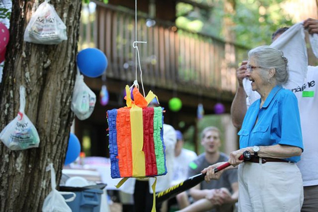 London takes a swing at the pinata during her 90th birthday celebration in August. The trees were decorated with bags, symbolizing her many years cleaning up Washougal River Road.