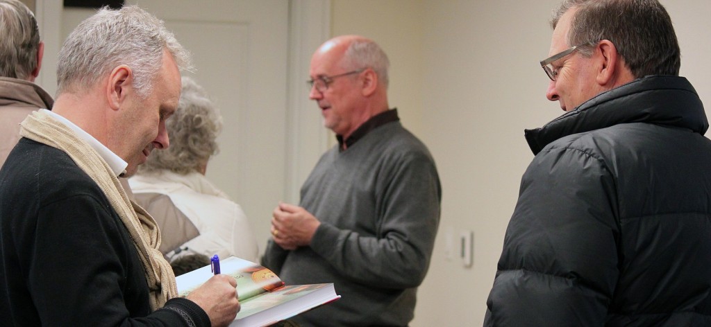 "The Burma Cookbook" authors Morrison Polkinghorne (left) and Robert Carmack (center) sign copies of their book and talk with friends and other community members who turned out for their presentation at the Camas Public Library on Wednesday.