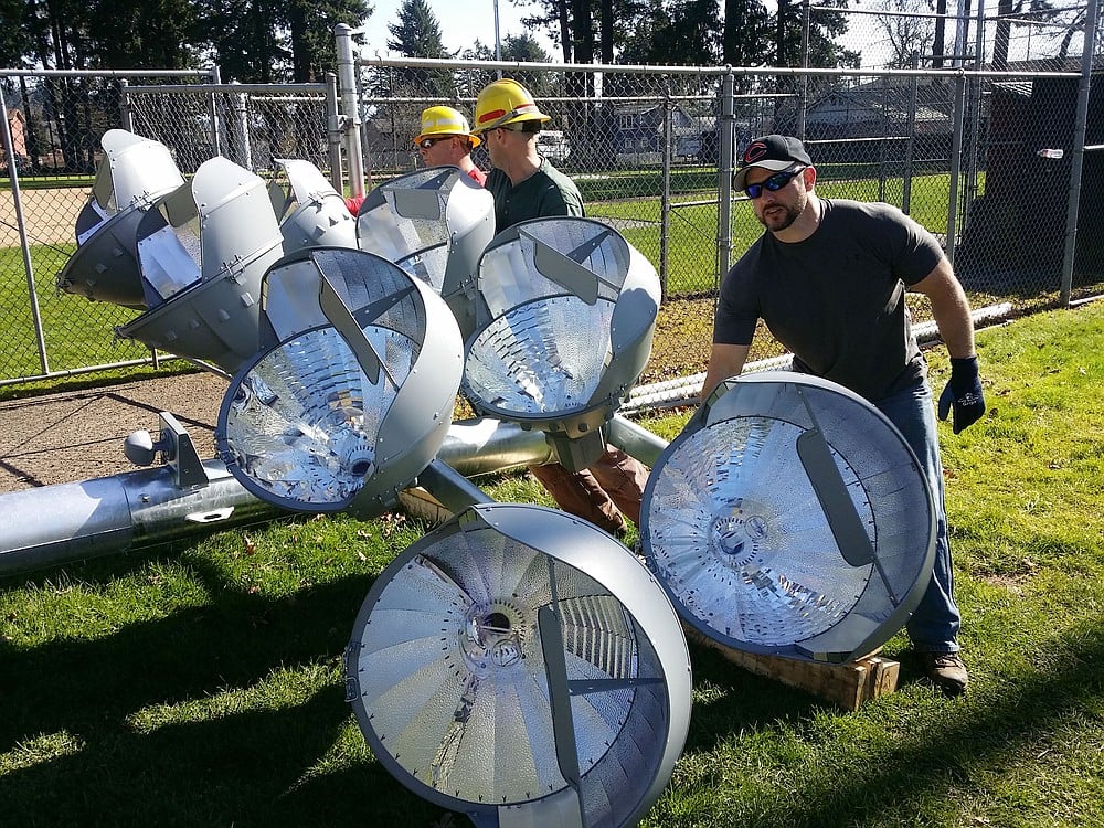 Camas-Washougal Babe Ruth Treasurer Randy Potter helps a few Clark PUD members move an 80-foot lighting pole.