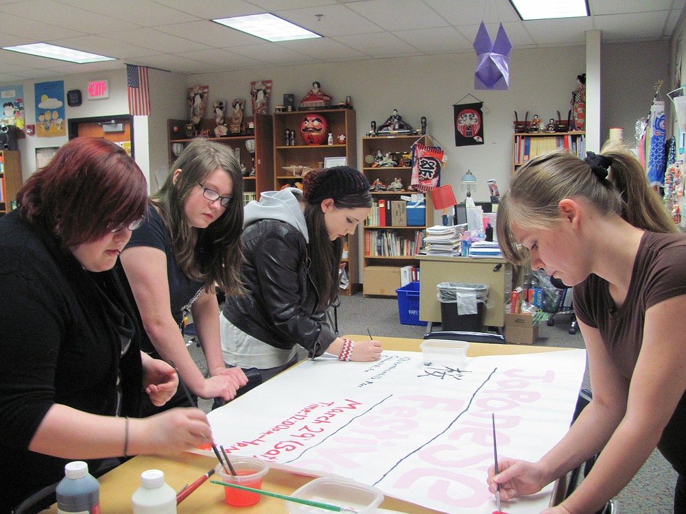 Clockwise, from left, Paula Raynor, Hannah Shilling, Breanna DeCicco and Chelsea Gaddy work on posters promoting the festival. Students spend several months preparing for the annual event.